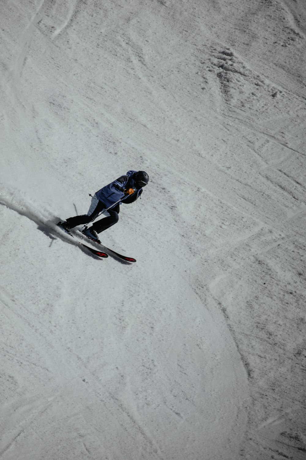 man in blue jacket and black pants riding snowboard on snow covered ground during daytime