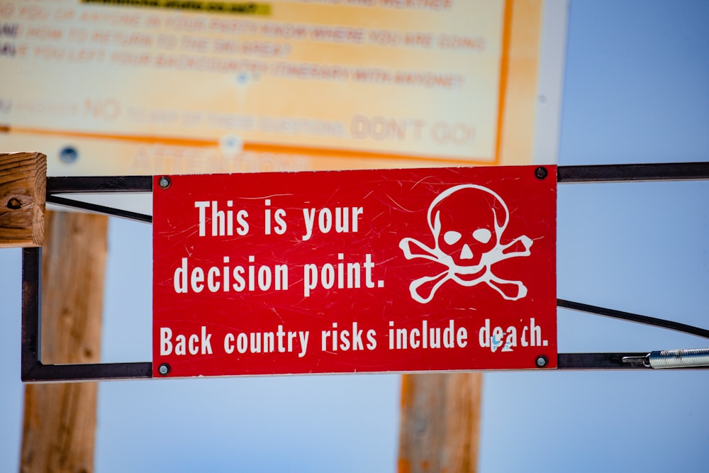 red and white signage on brown wooden post