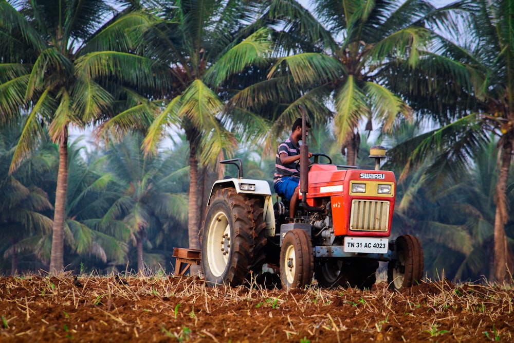 blue and red tractor on brown grass field during daytime