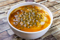 Close-up of a tropical dessert bite with a drizzle of passion fruit sauce.