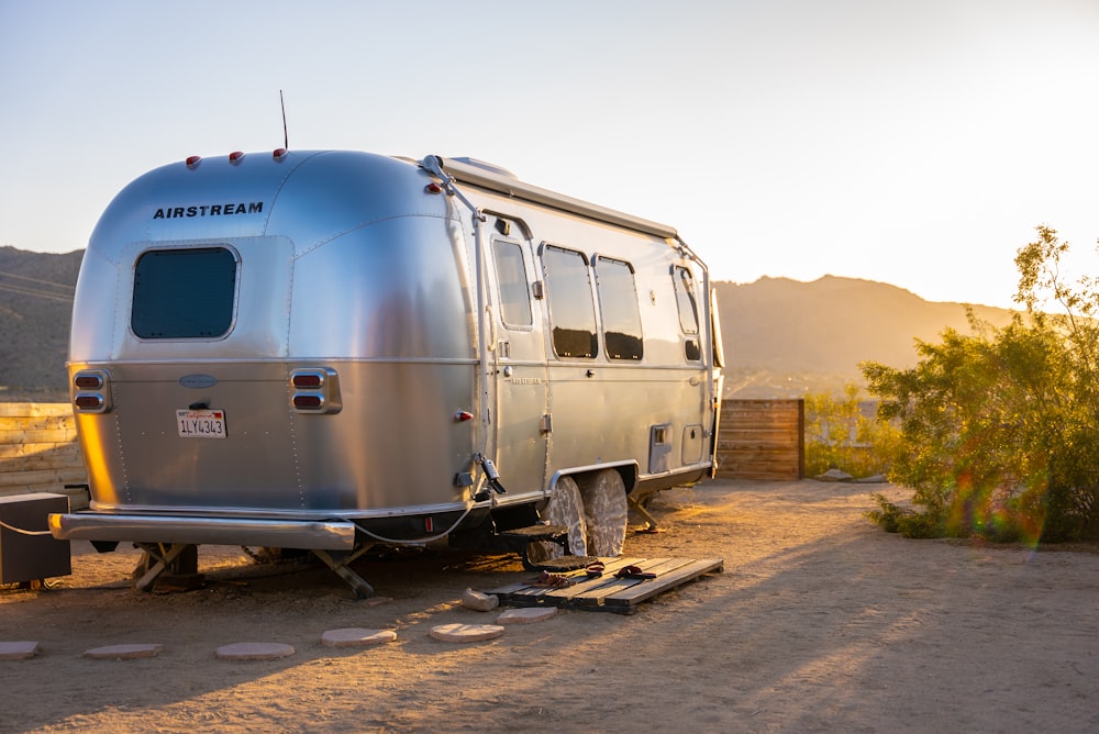 white and blue van on brown dirt road during daytime