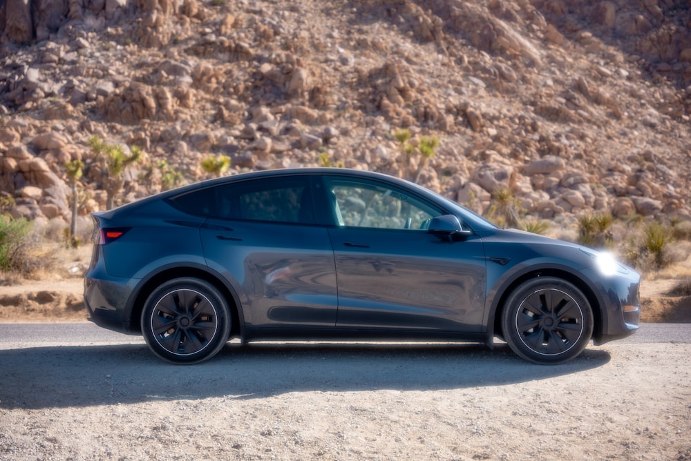 blue sedan on gray dirt road during daytime