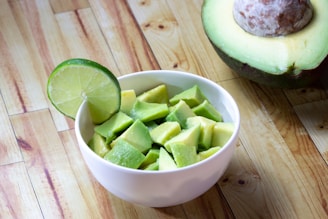 sliced green fruit in white ceramic bowl