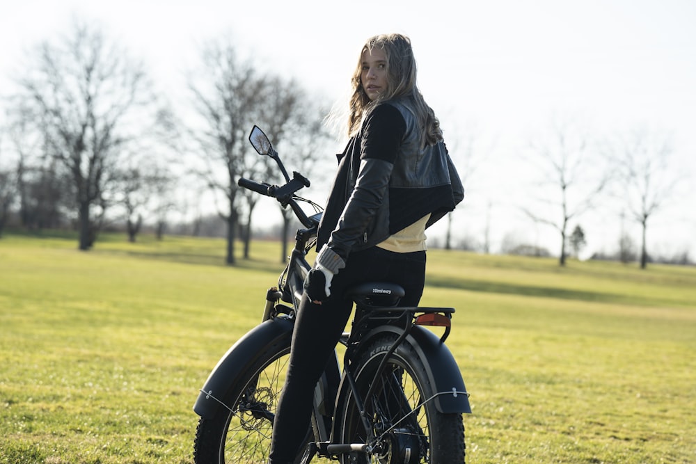 woman in black jacket riding on black motorcycle during daytime