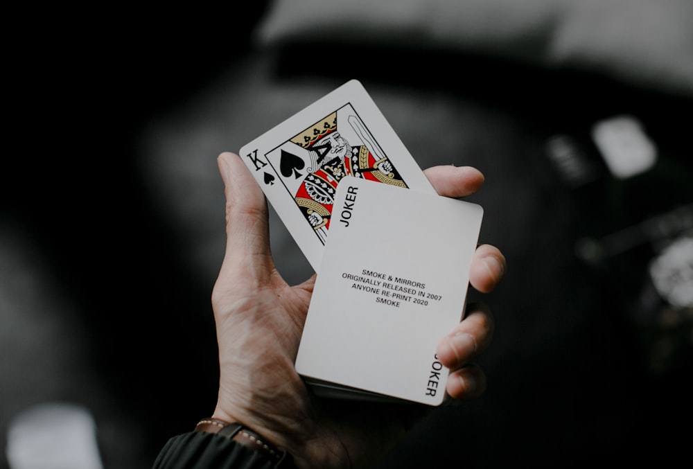 person holding joker playing card