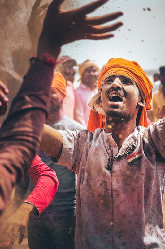 Man with turban covered in colorful Holi powder. Photo by Harsh Pandey on Unsplash.