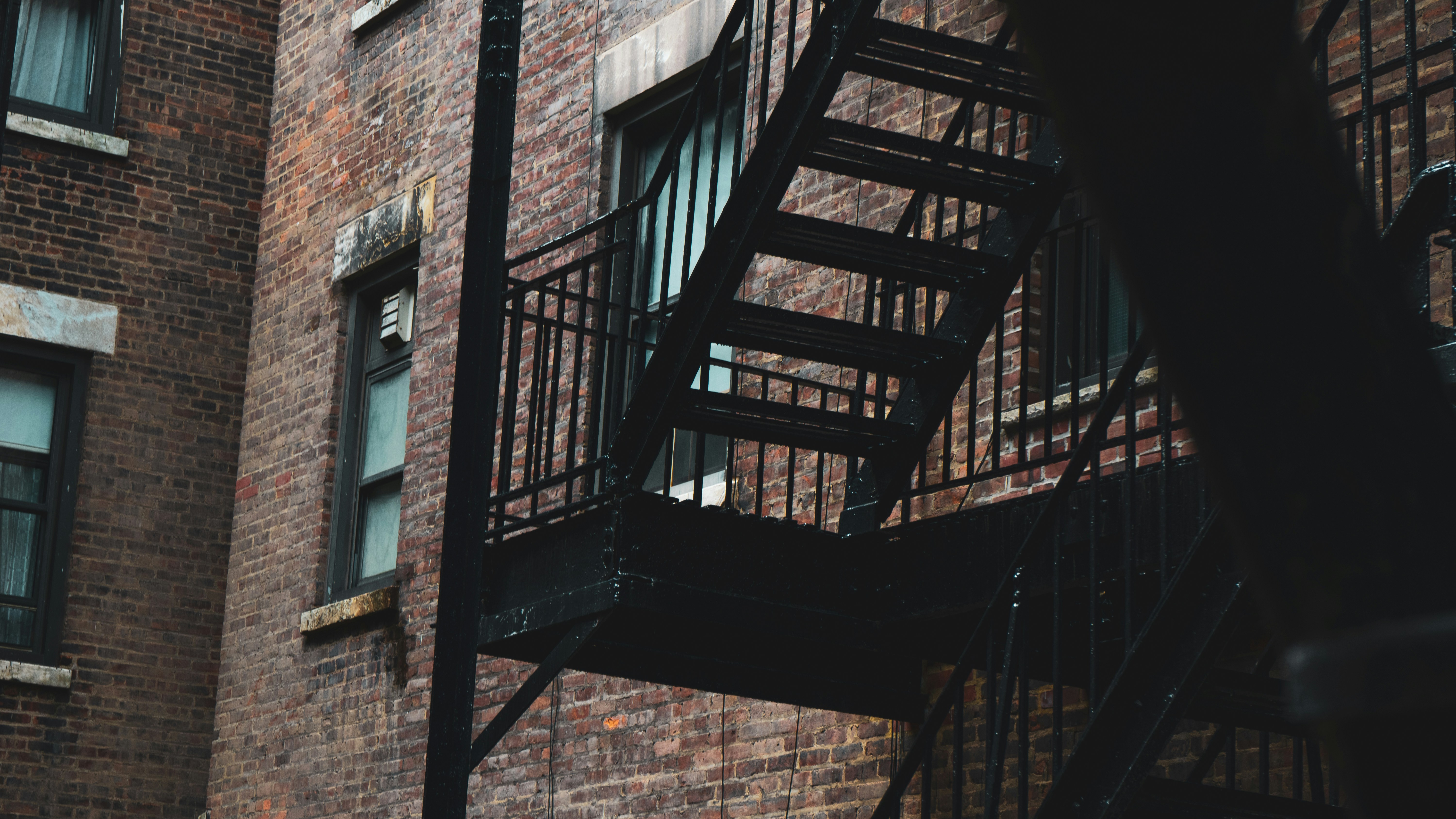 brown wooden staircase on brown brick wall