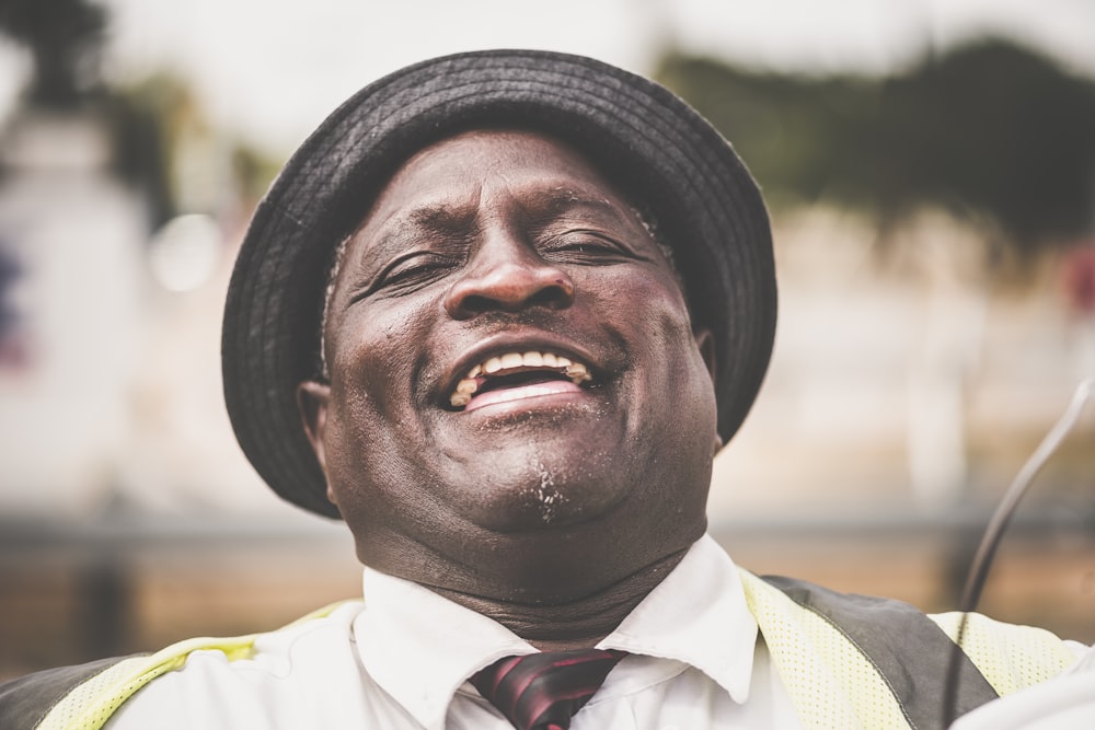 man in yellow and white collared shirt wearing black hat