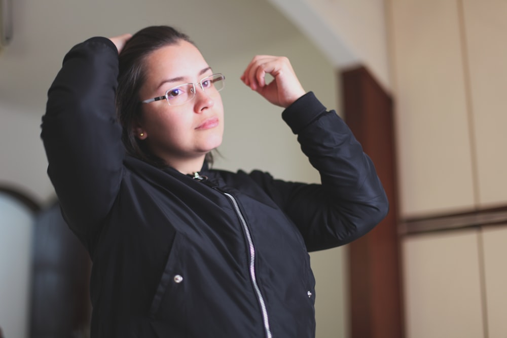 woman in black jacket wearing white earbuds