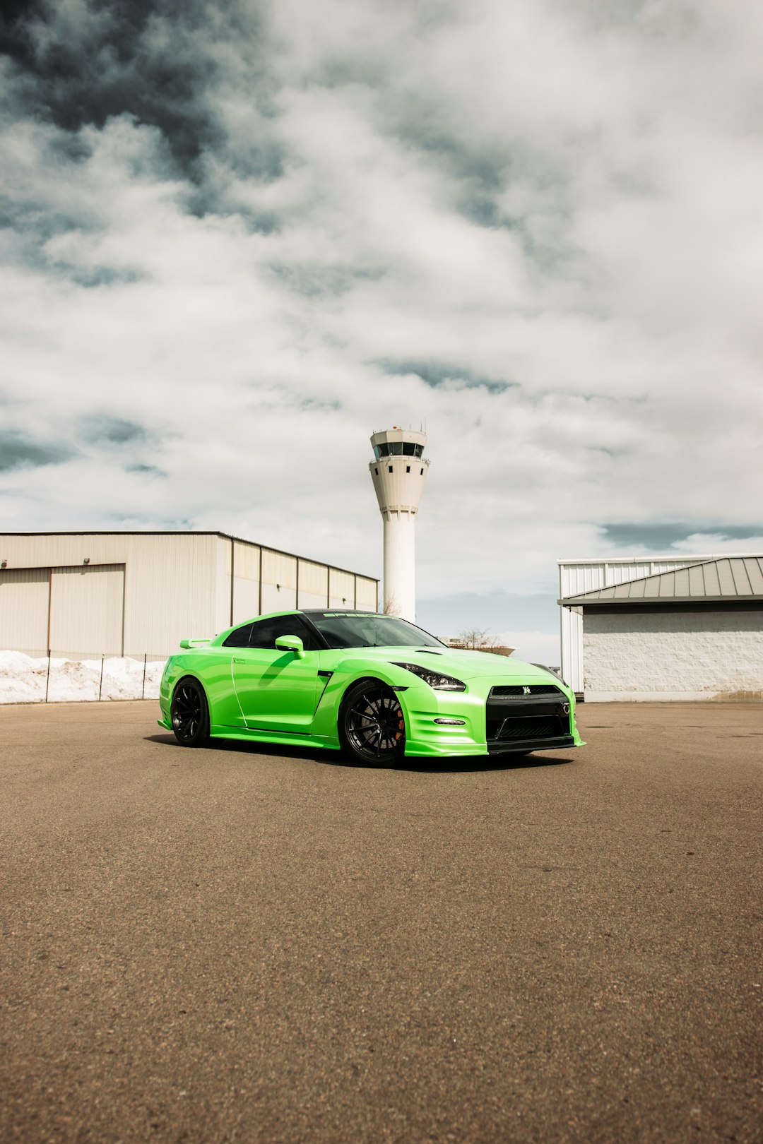 green porsche 911 parked near white building