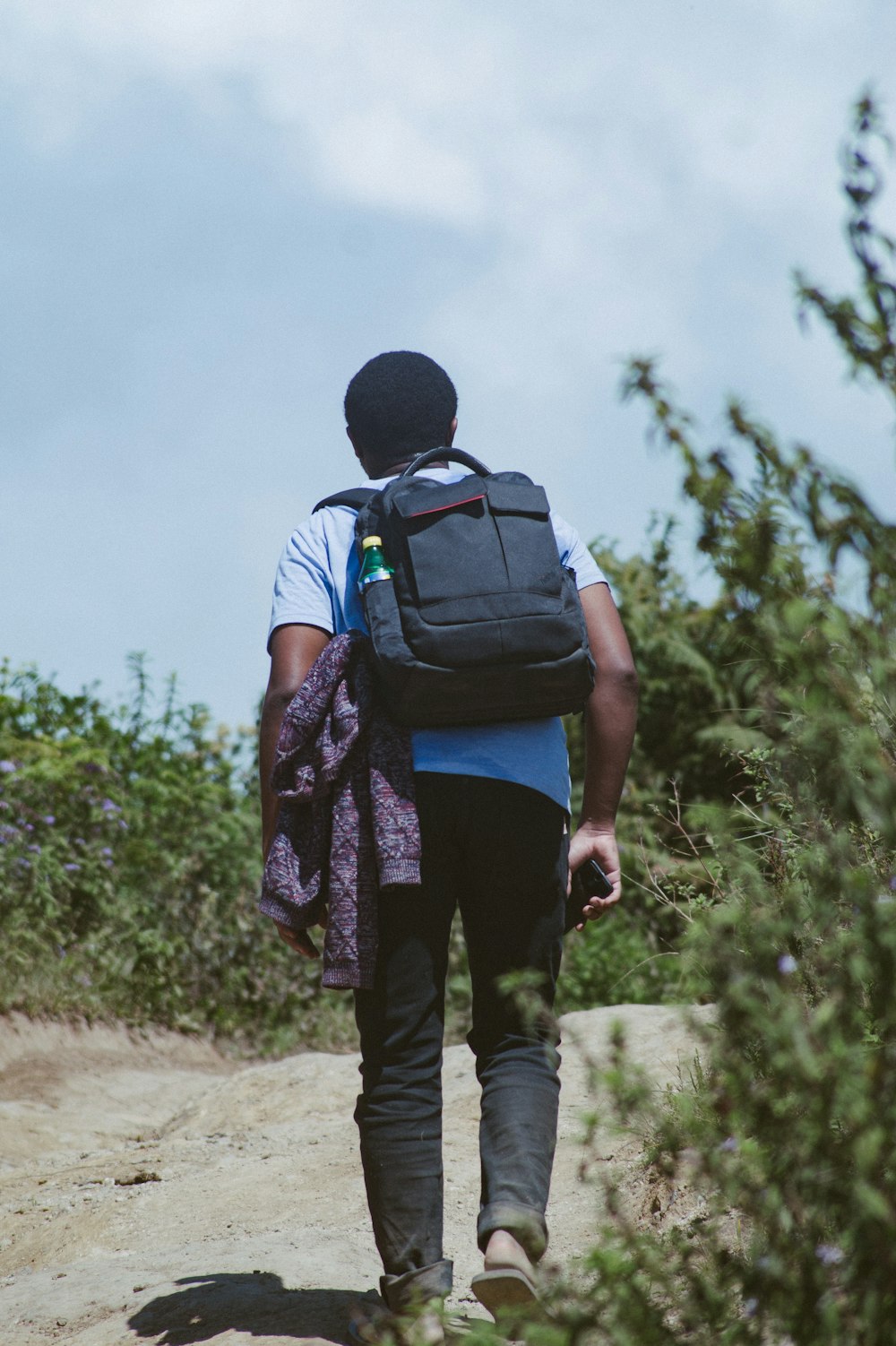 Foto mochila negra y caminando por un camino de tierra durante el día – Imagen Mbeya gratis en Unsplash