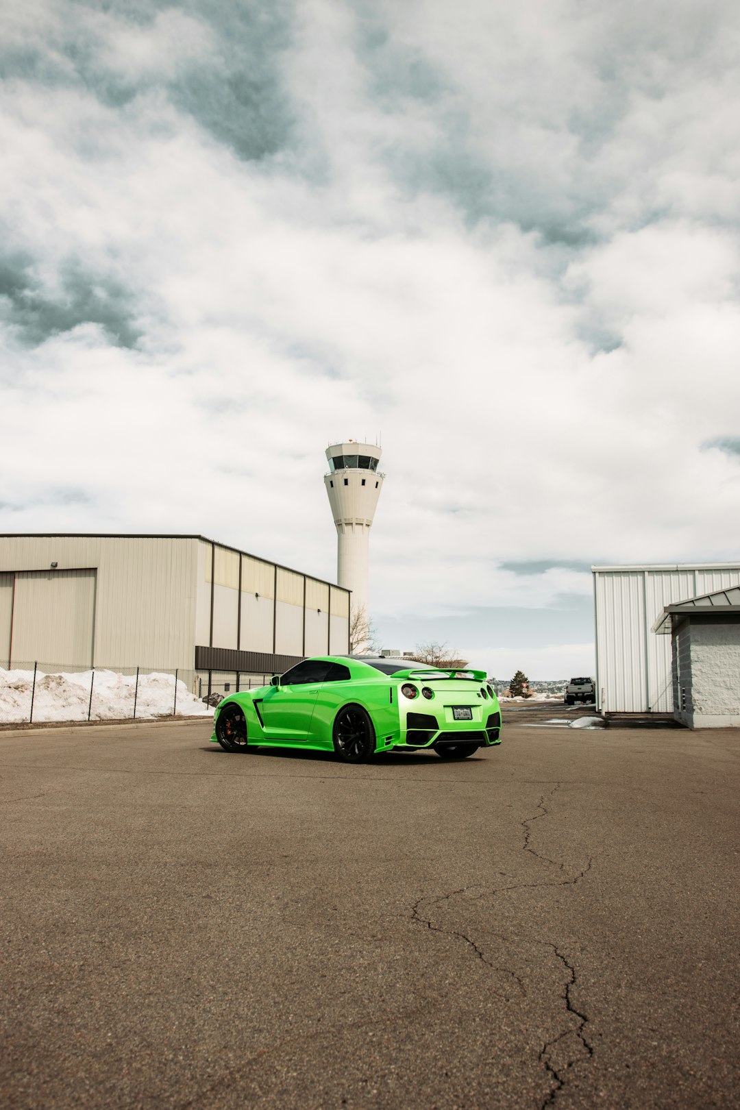 green and black sports car parked near white building