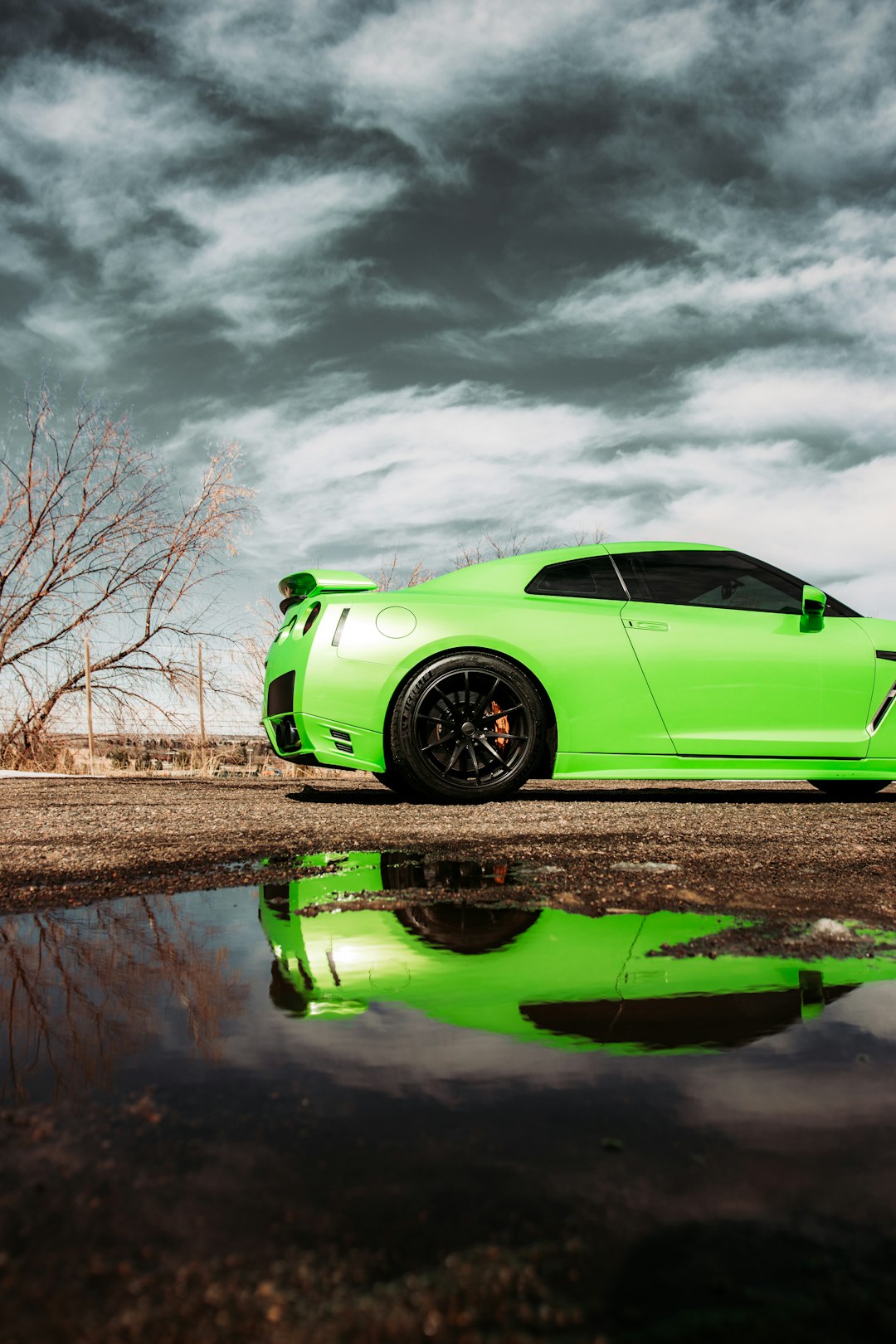 green coupe parked beside body of water during daytime