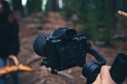 black dslr camera on brown wooden table
