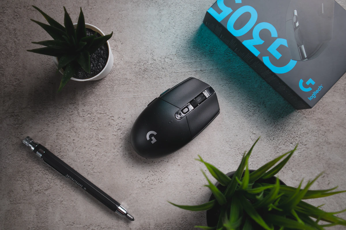 Black hp cordless computer mouse beside black click pen