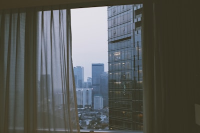 A vibrant cityscape view from a luxurious hotel window, highlighting comfort and style.