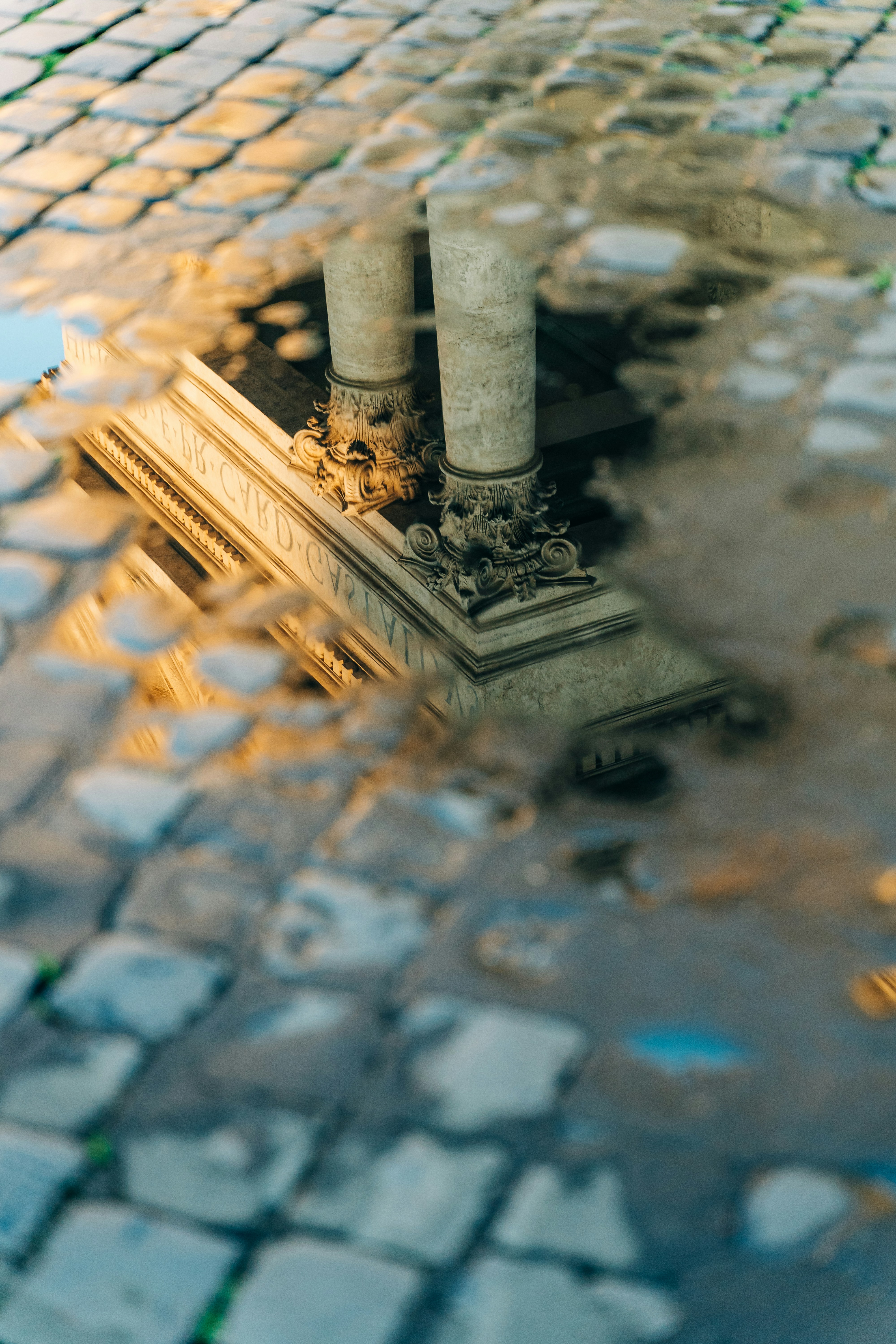 Antique columns reflected in a puddle in Rome, Italy