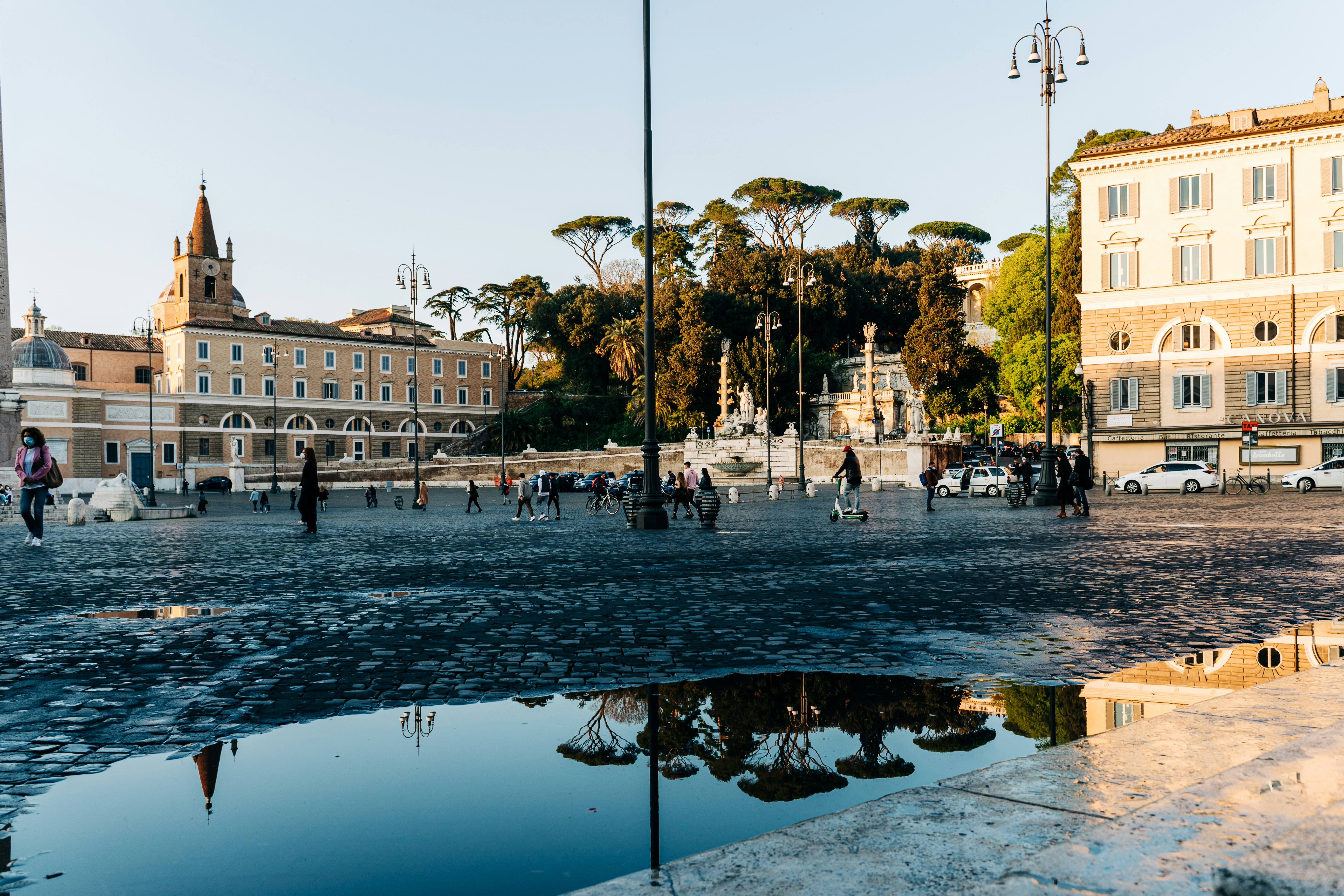 Umbrella pines in Villa Borghese reflected in a puddle in Piazza del Popolo in Rome, Italy