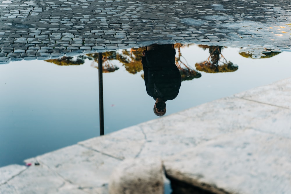 person in black jacket standing on dock during daytime