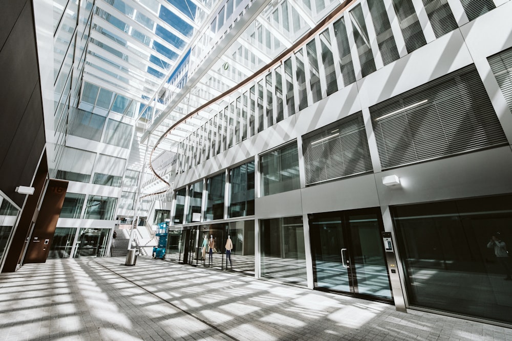 people walking on sidewalk near glass building during daytime