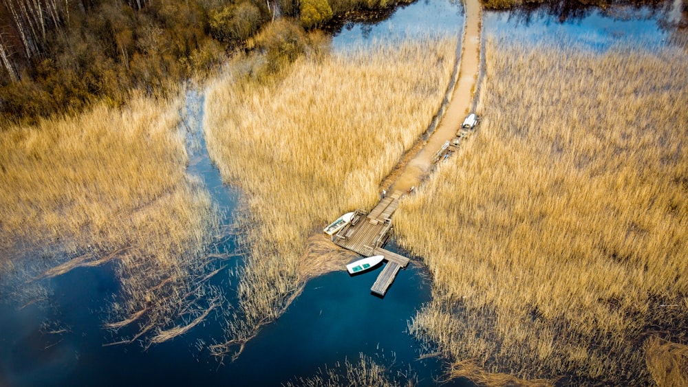 aerial view of lake in the middle of brown grass field during daytime