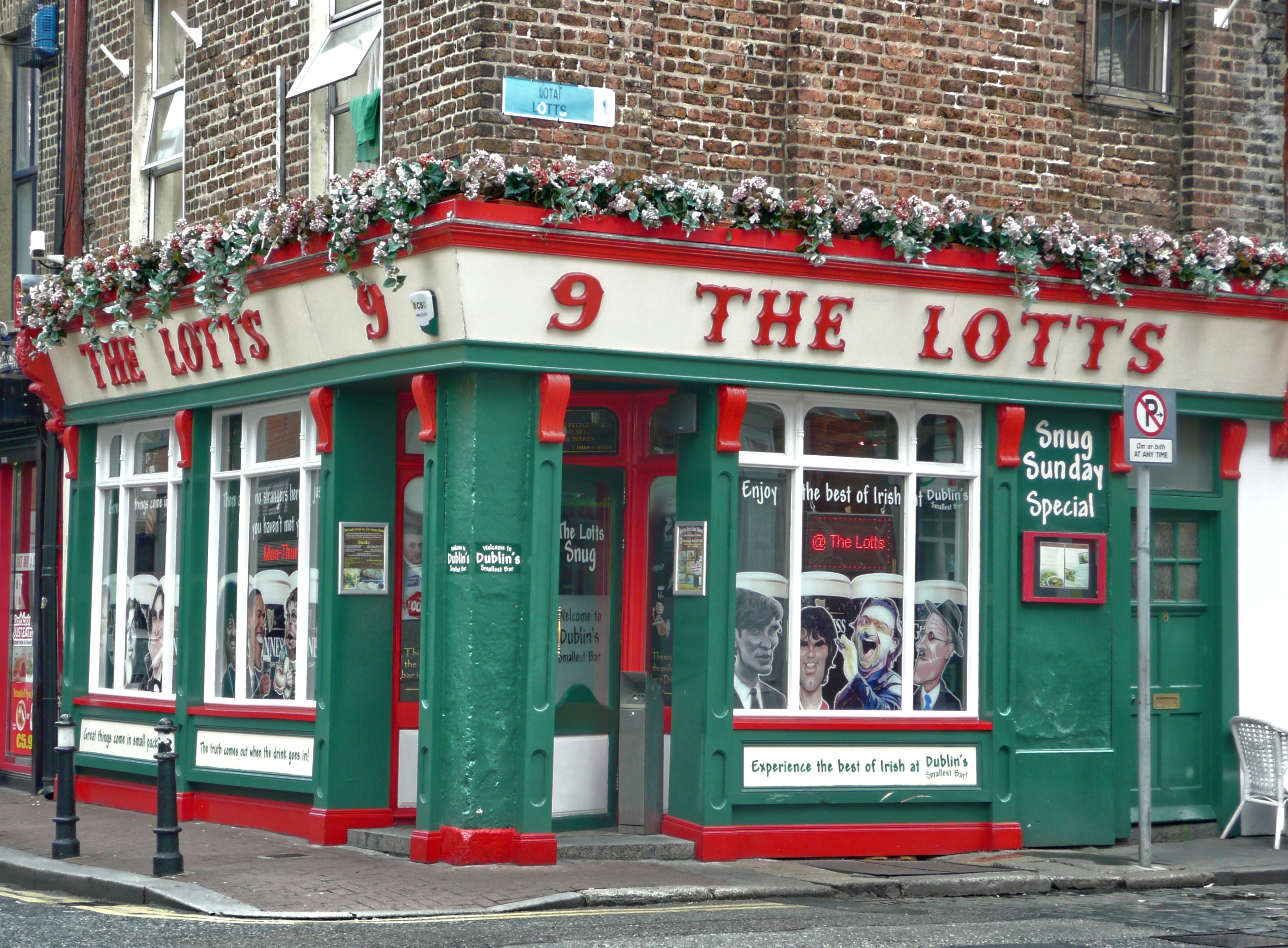 red and white store front during daytime, Le pub The Lotts est le plus petit café typique de Dublin.