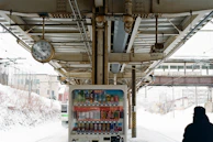 A colorful iccaro popcorn vending machine at a bustling train station, catching the eye of travelers.