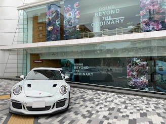 A sleek, modern storefront of RR Garagem with tinted windows reflecting the cityscape.