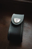 Collector storage case made from rigid board with metal logo plates and velvet lining.