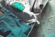 A suitcase is partially packed with a pair of blue jeans, a white T-shirt with a graphic of the Earth, and colorful sneakers. The suitcase is placed on top of a detailed map, suggesting travel plans.