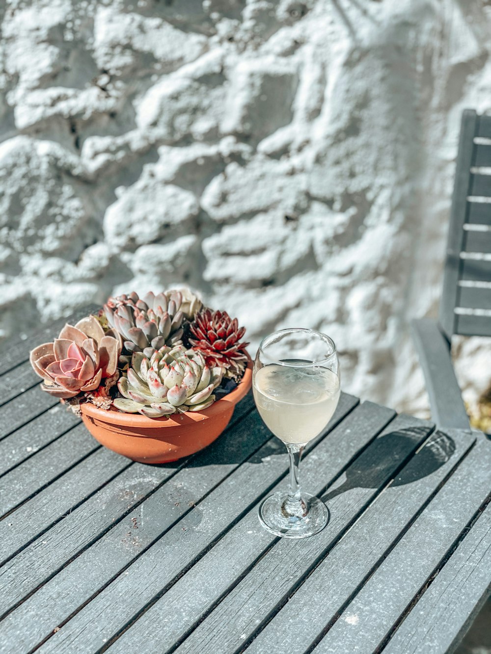 clear wine glass with pink liquid on brown wooden table