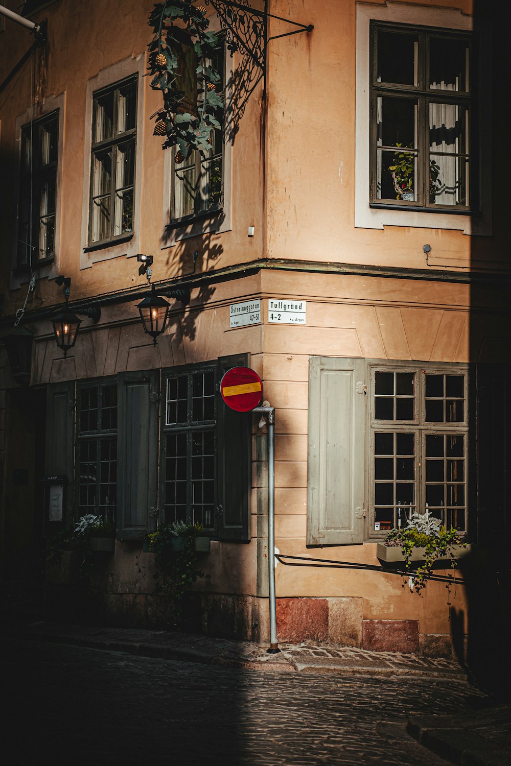 red and black outdoor lantern on brown concrete building