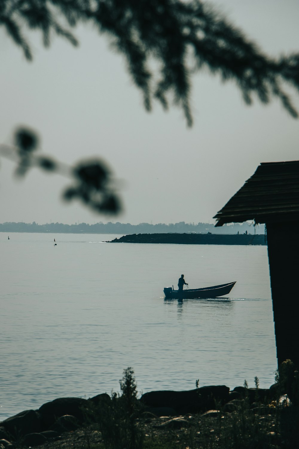 silhouette of person riding on boat on body of water during daytime