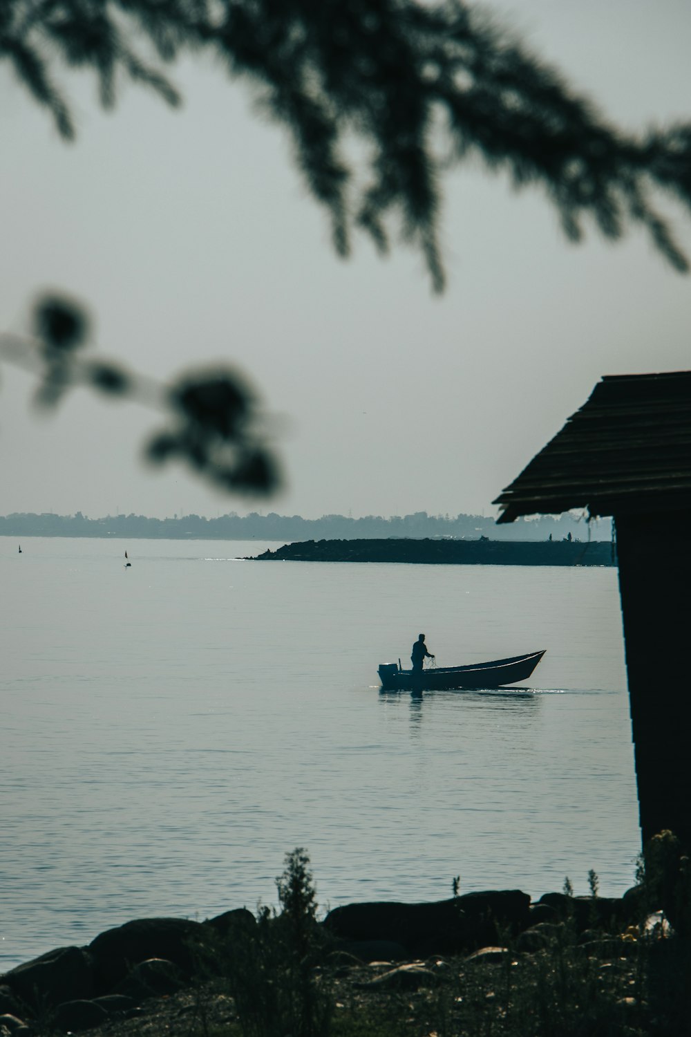 Silhouette der Person, die tagsüber auf dem Boot auf einem Gewässer fährt