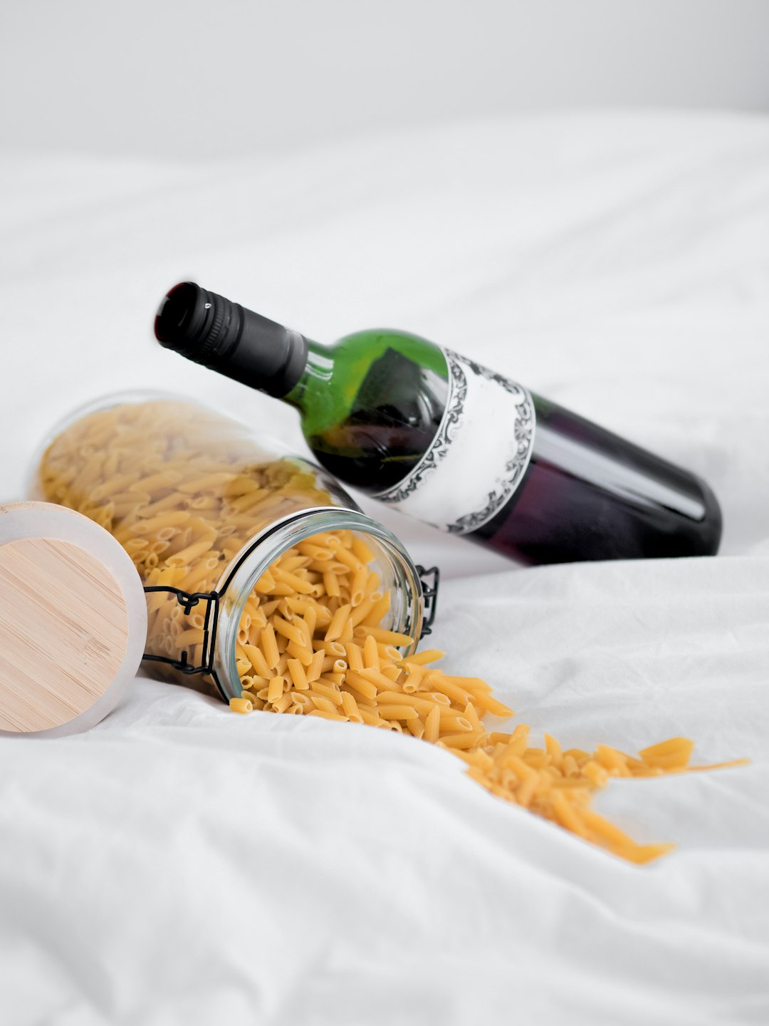 green glass bottle beside brown wooden round bowl