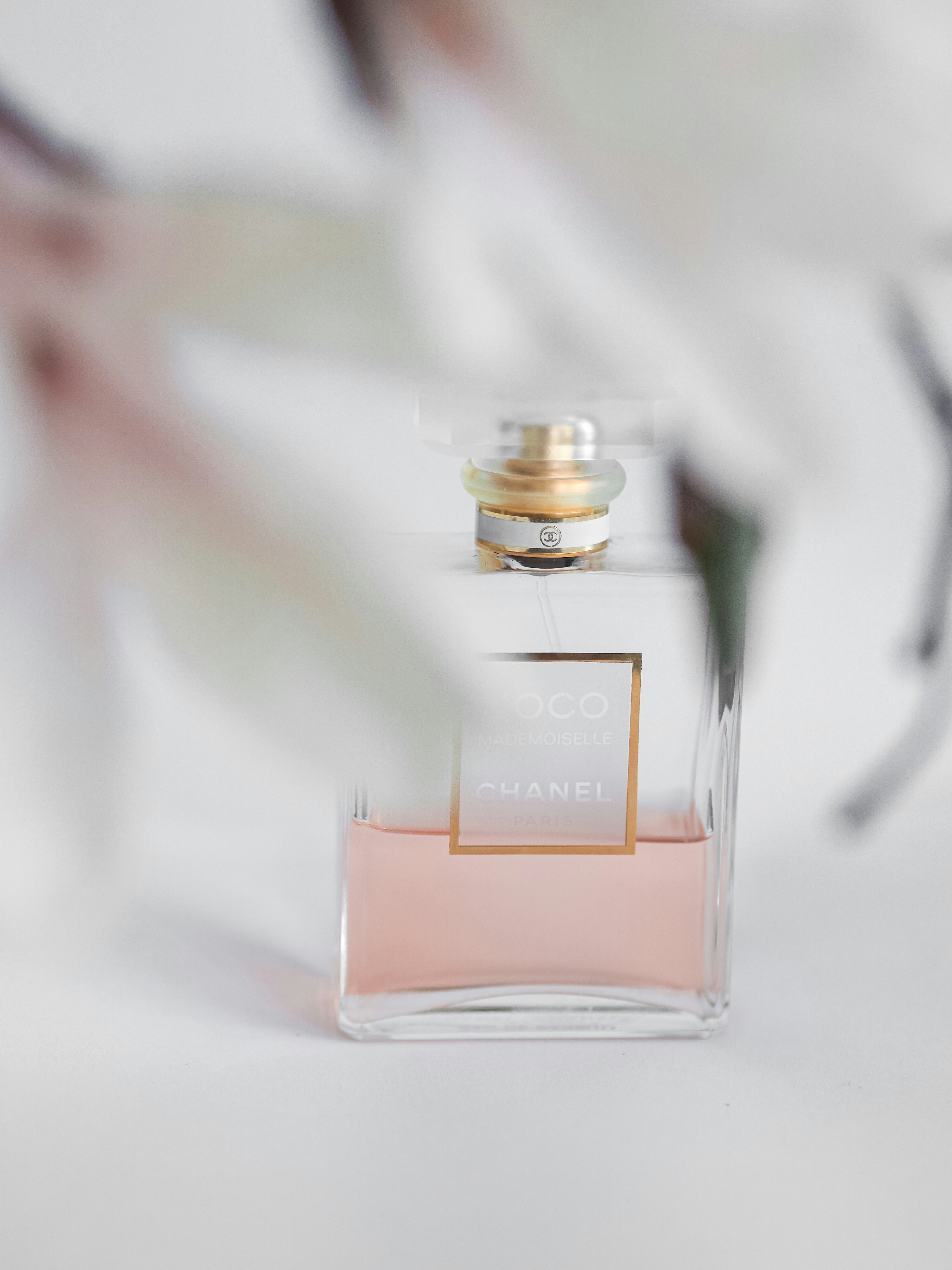 clear glass perfume bottle on white table