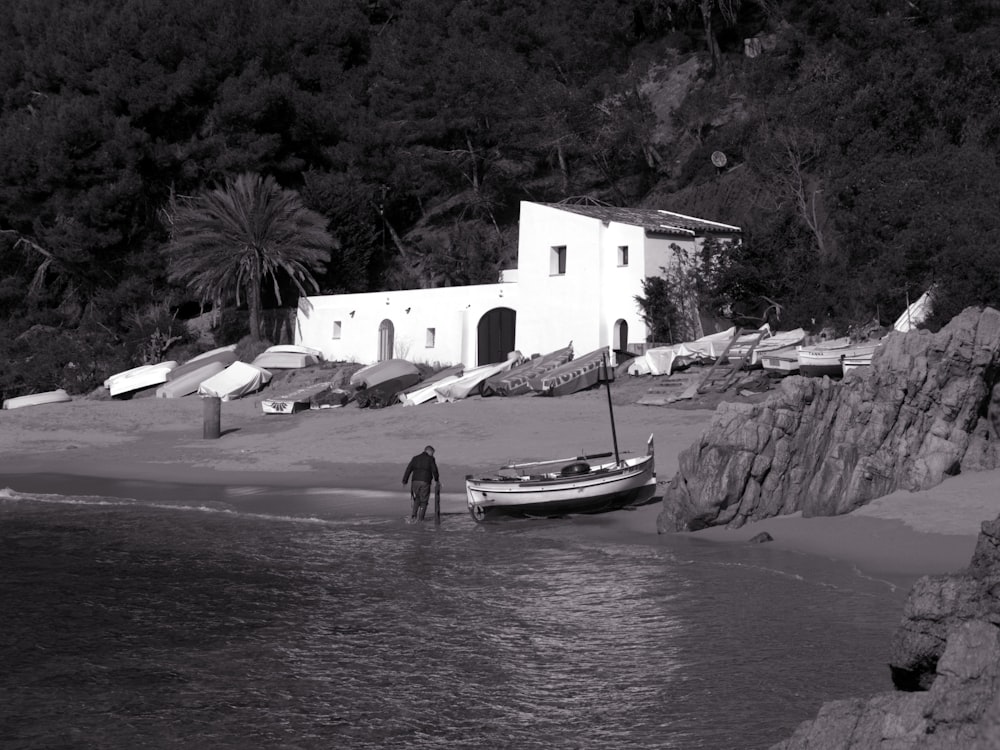 white and black boat on body of water near white concrete building during daytime