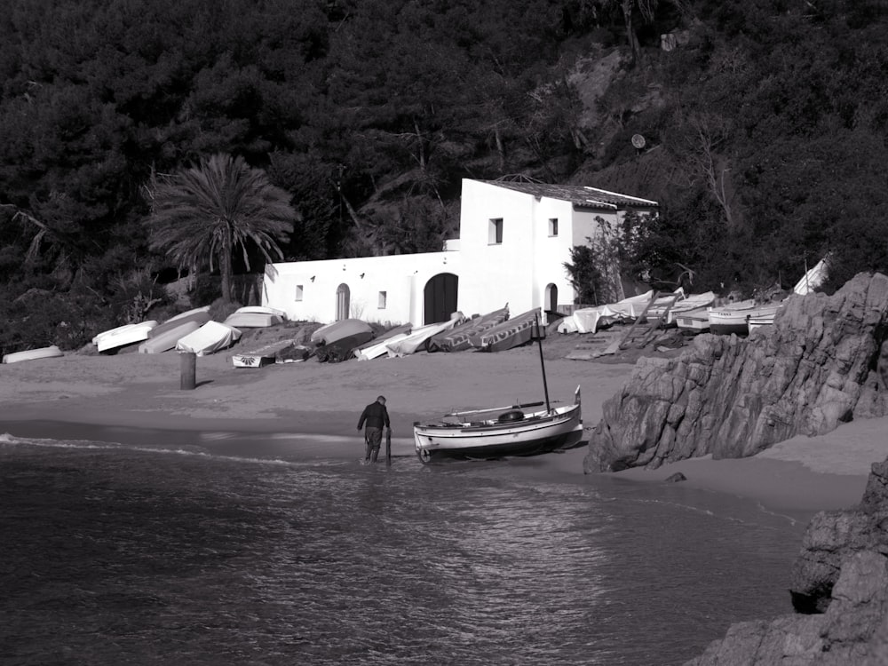 Barco blanco y negro en cuerpo de agua cerca de un edificio de hormigón blanco durante el día