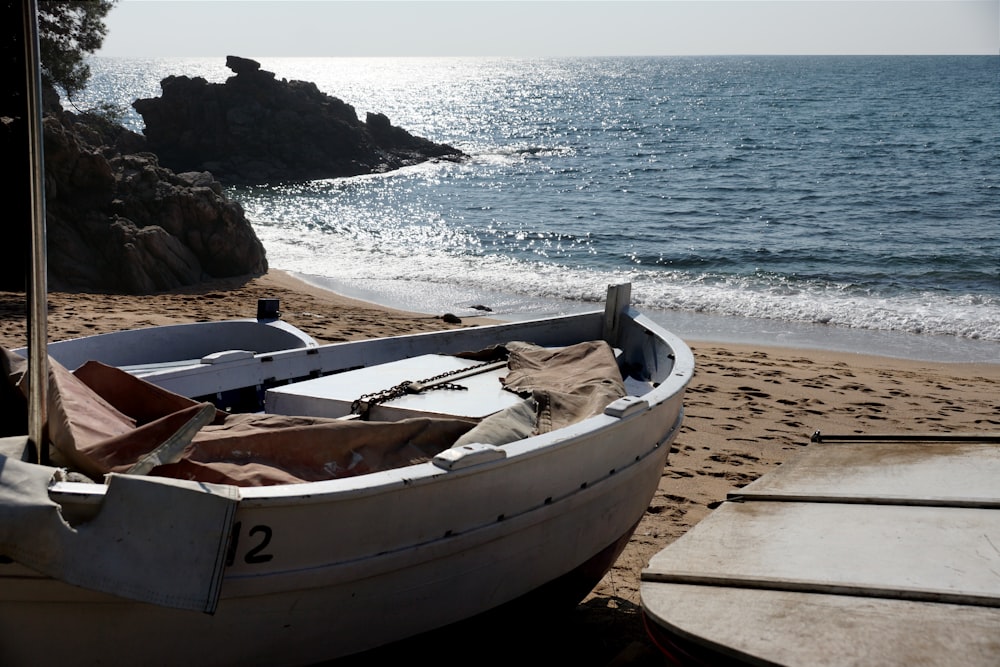 Barco blanco y marrón en la playa durante el día