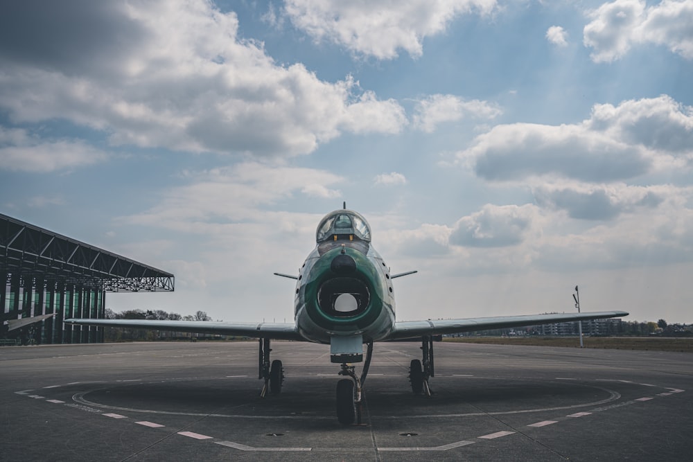 green and black plane on airport during daytime