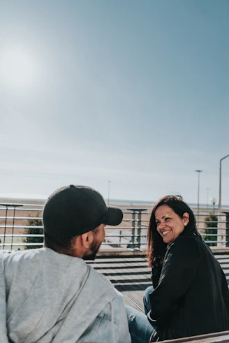 man in gray shirt beside woman in black jacket
