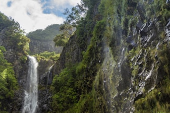 waterfalls in the middle of green and brown mountain