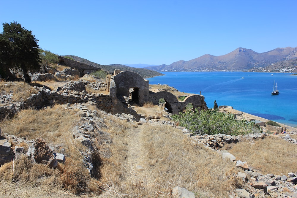 brown rock formation near blue sea under blue sky during daytime