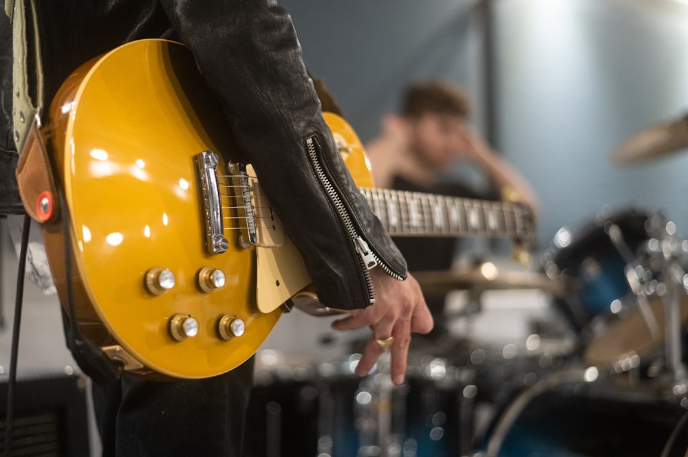 man in black suit playing brown electric guitar