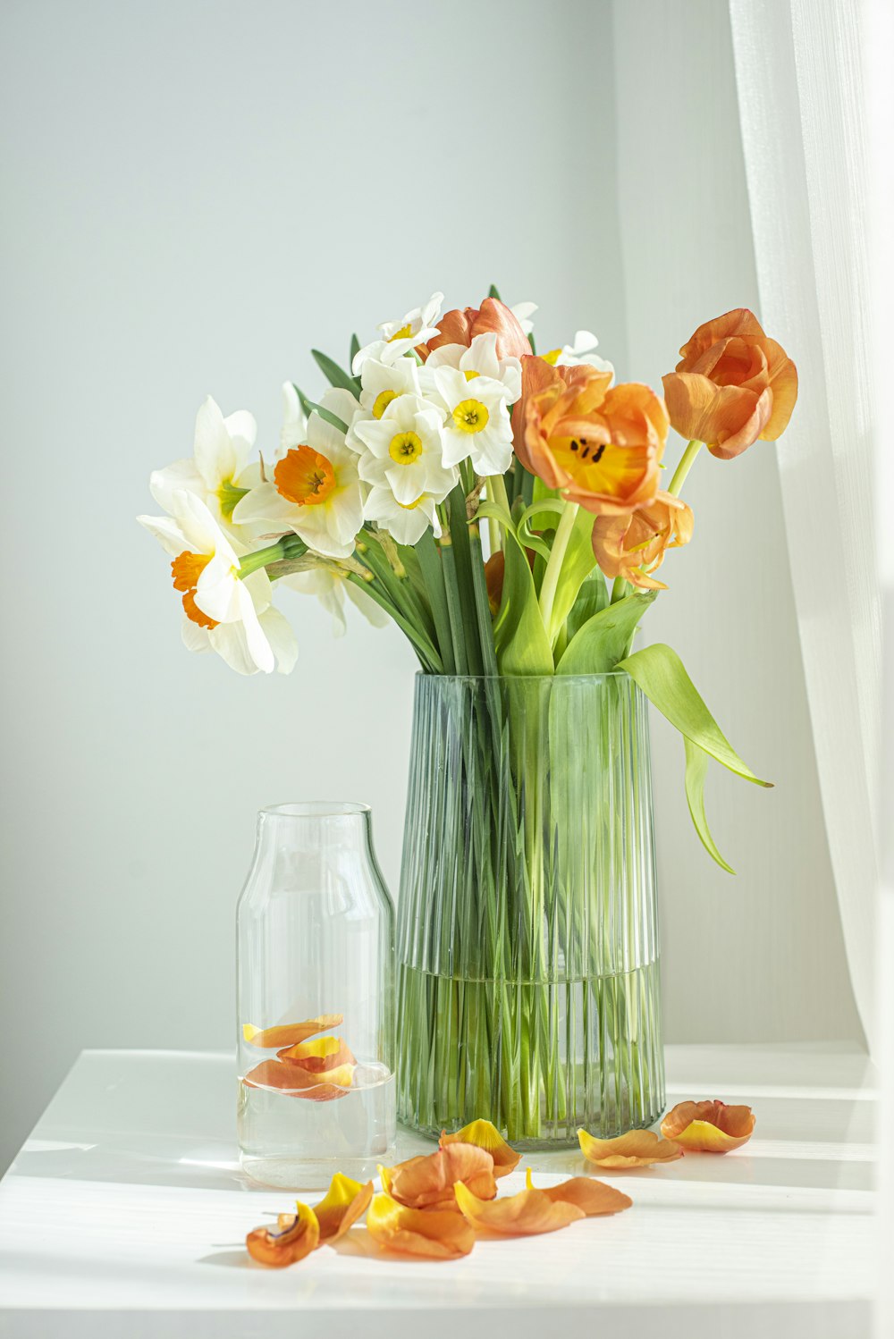 orange and yellow flowers in clear glass vase