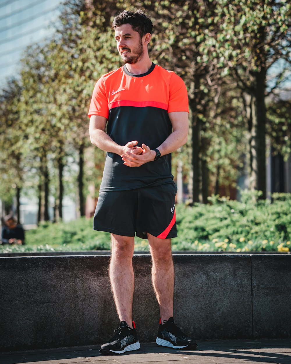 Foto hombre en camiseta roja con cuello redondo de Nike y pantalones cortos  negros parados en pavimento de hormigón gris – Imagen Glasgow gratis en  Unsplash