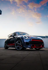 High-resolution photo of a sleek sports car at a sunset car meet.