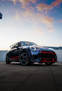 High-resolution photo of a sleek sports car at a sunset car meet.