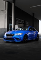 blue bmw m 3 coupe parked near building