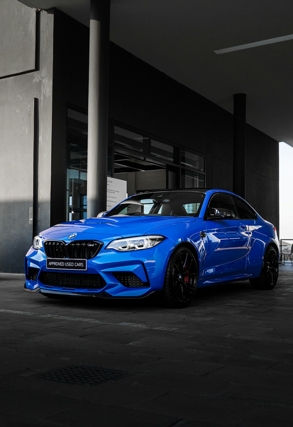 blue bmw m 3 coupe parked near building